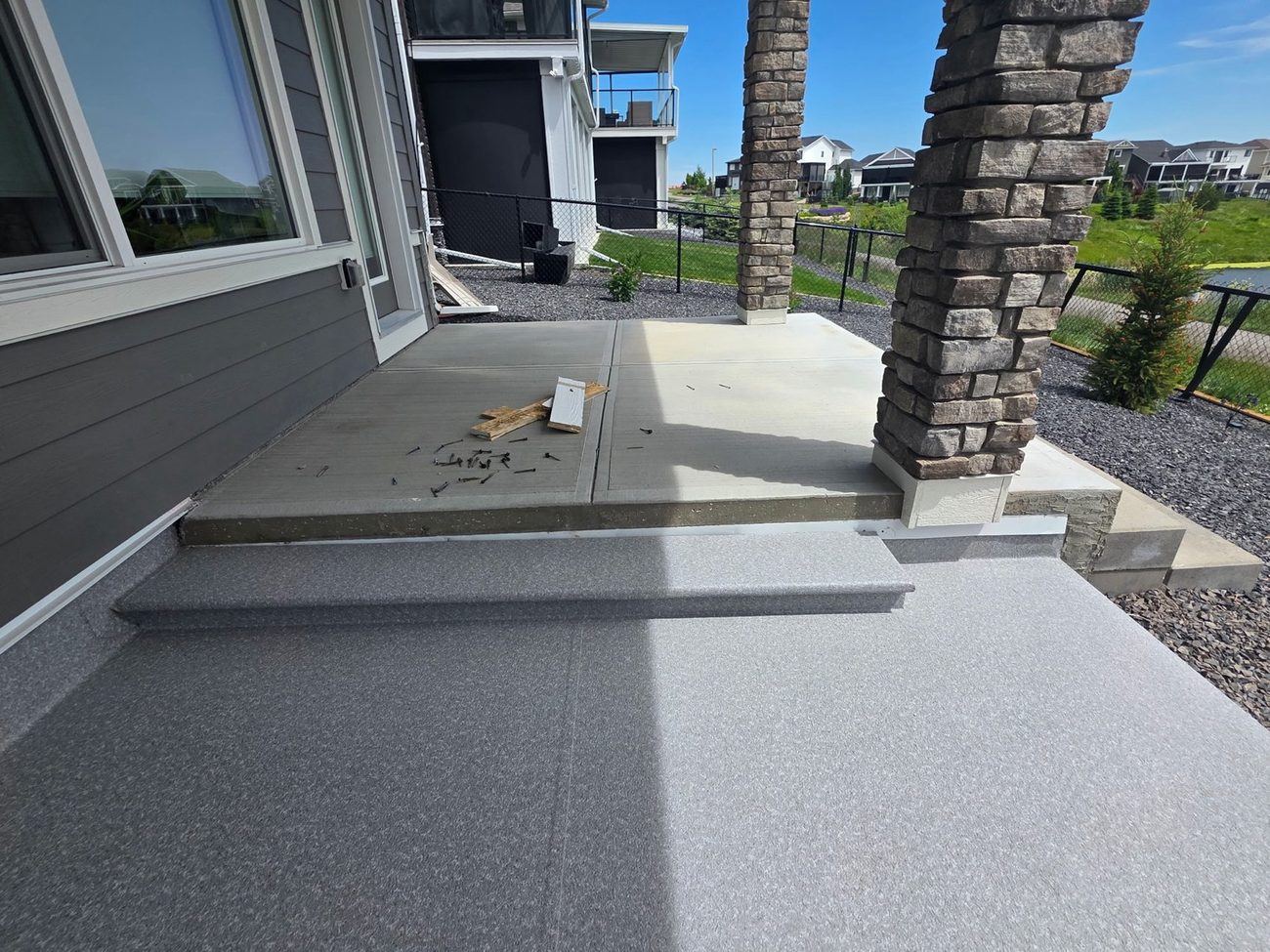 Finished waterproof vinyl deck with stone columns on a new home