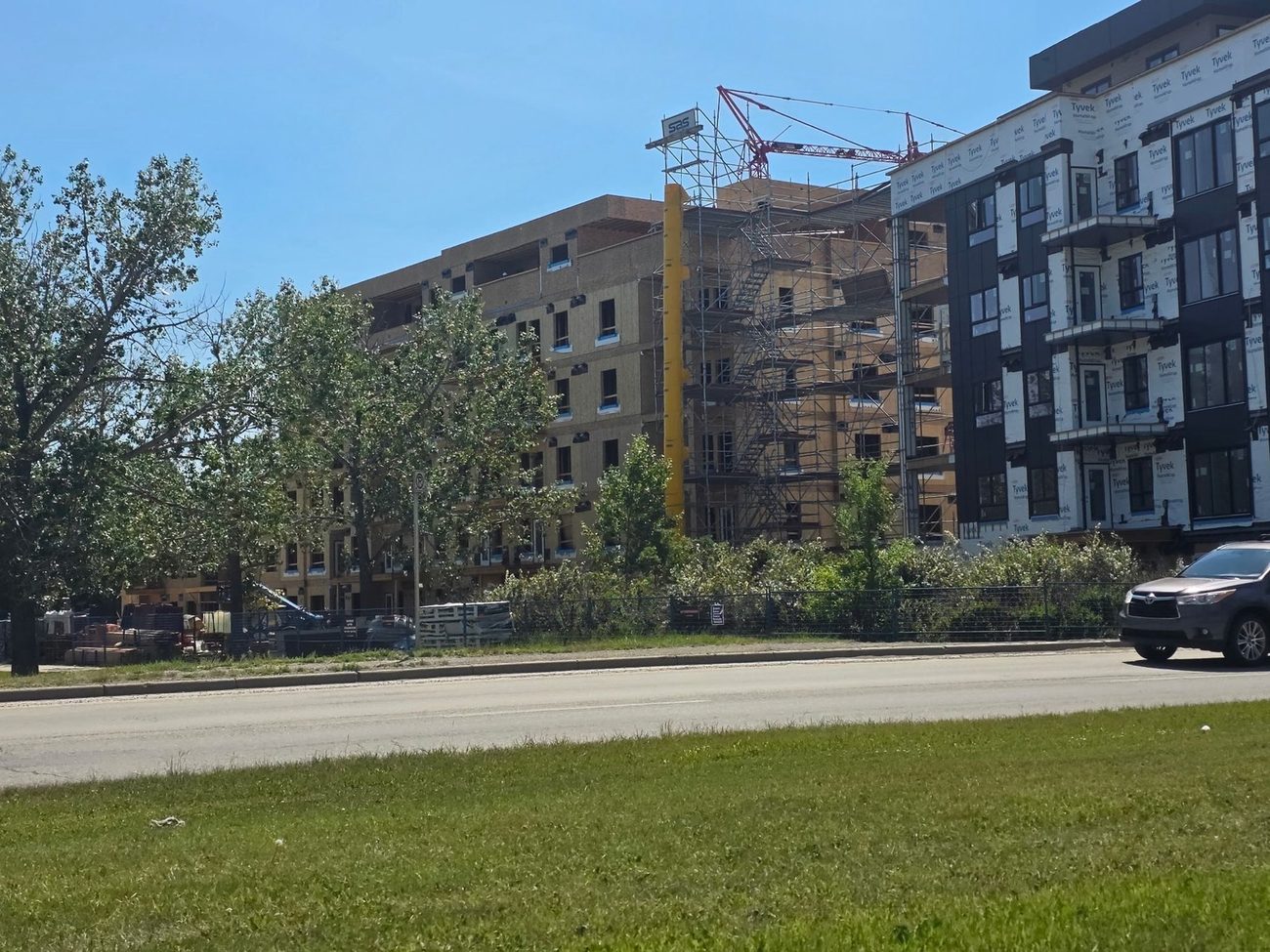 Twin apartment buildings with scaffold and crane